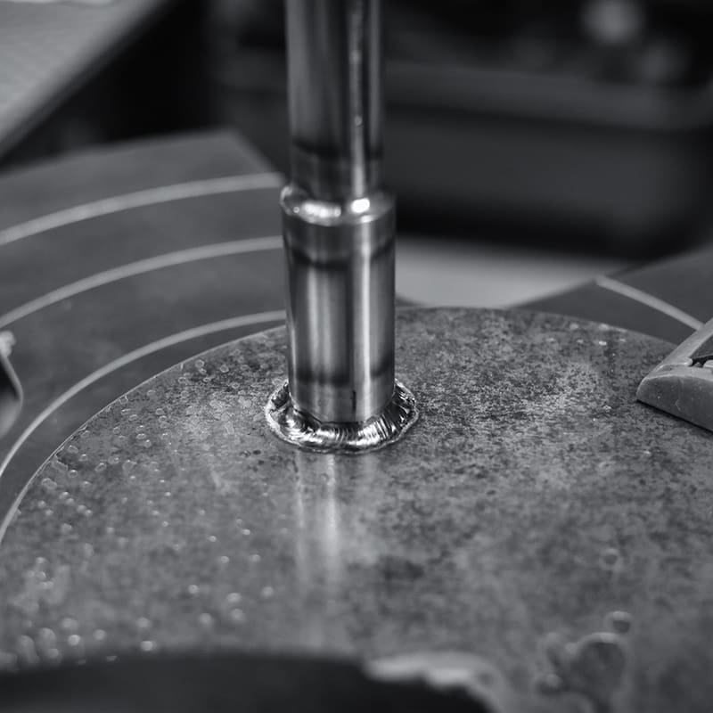 GANZ製スタンドライトのアームパイプとベース接続部をTIG溶接。ポジショナーを用いた回転溶接により、全周にわたり均一なビード(溶接痕)を形成。